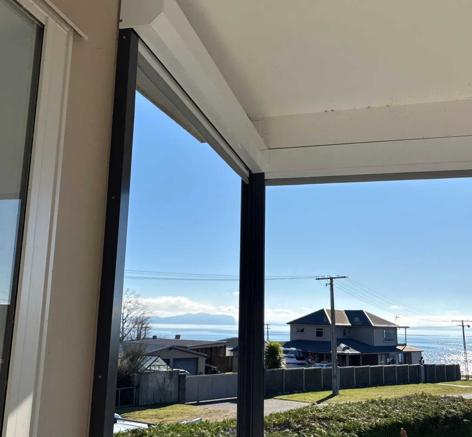 White Executive motorised screen housing and recessed corner tracks under a veranda soffit at Lake Taupō