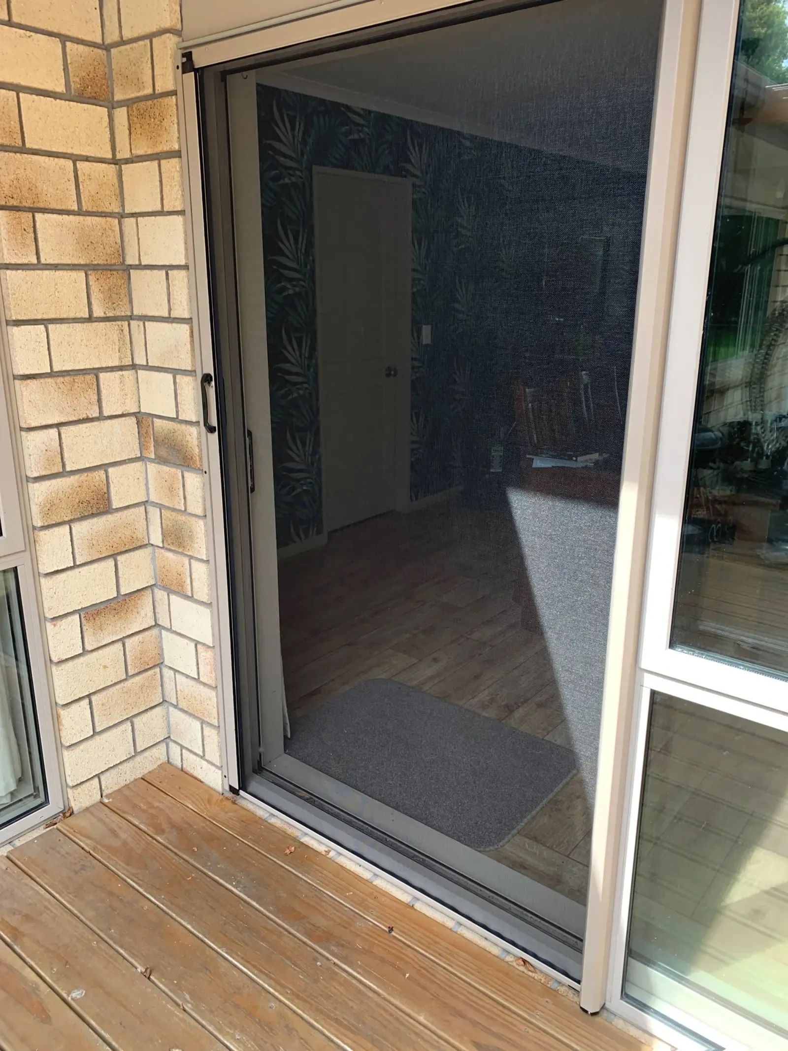 MeshLock screen on the dining slider of a brick Matamata home, hallway visible through the mesh