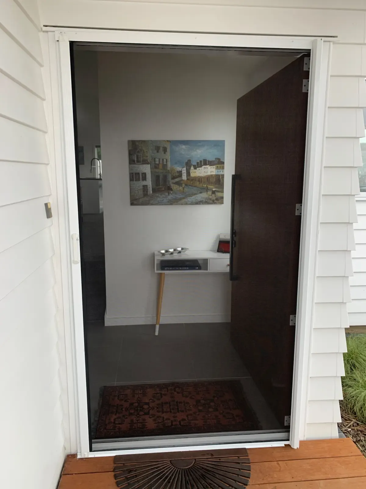 Appliance White MeshLock screen on a Taupō front door, opening to an entry hall
