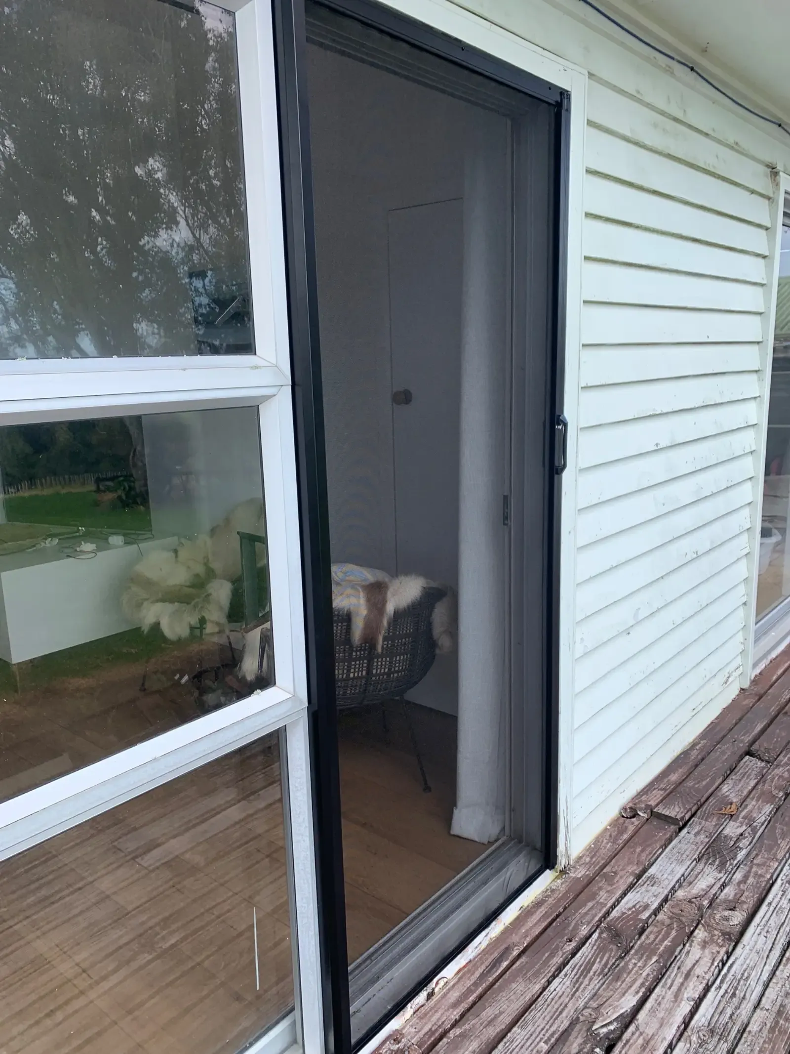 MeshLock screen across a weatherboard cottage slider, the dog dozing inside