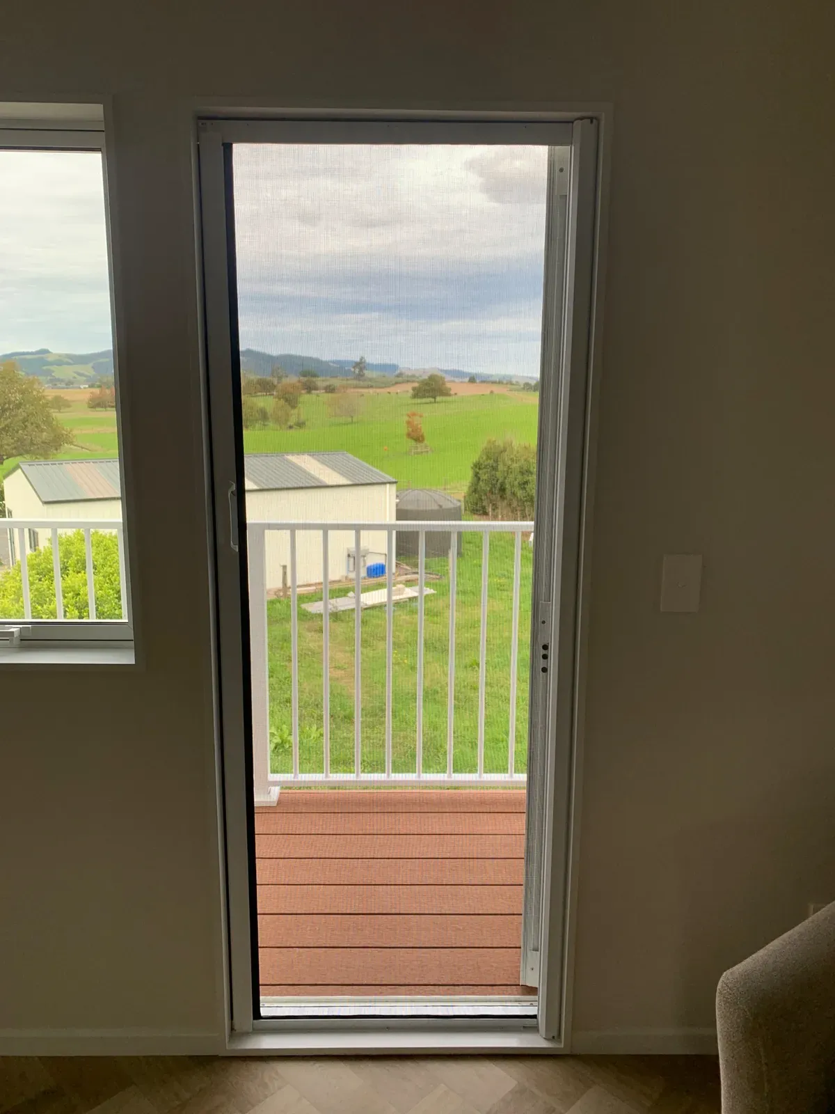 Warm white MeshLock door screen framing a rural Te Kauwhata view from a sitting room