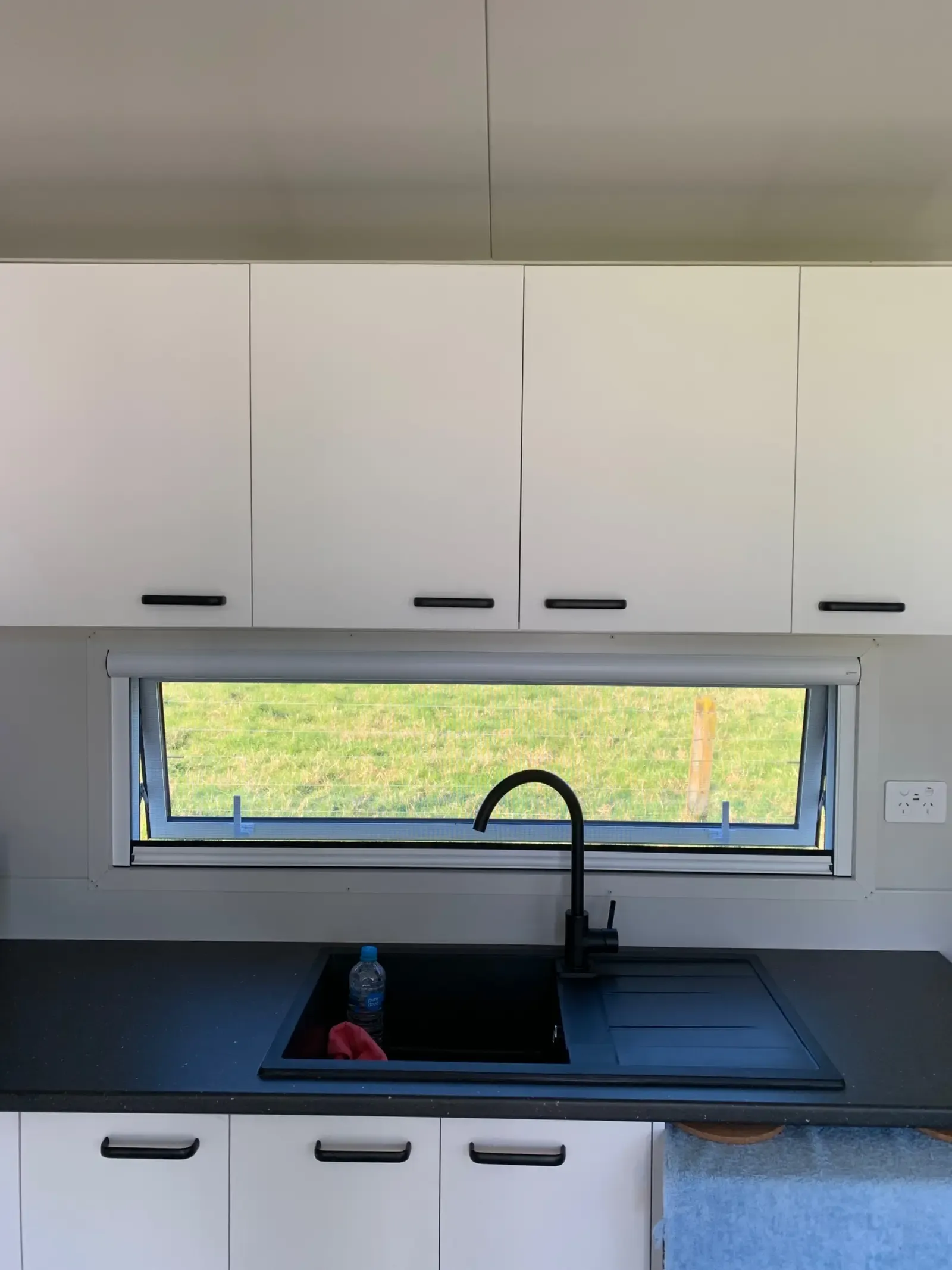 Serene screen fitted to a relocatable cabin kitchen window at Pukehina