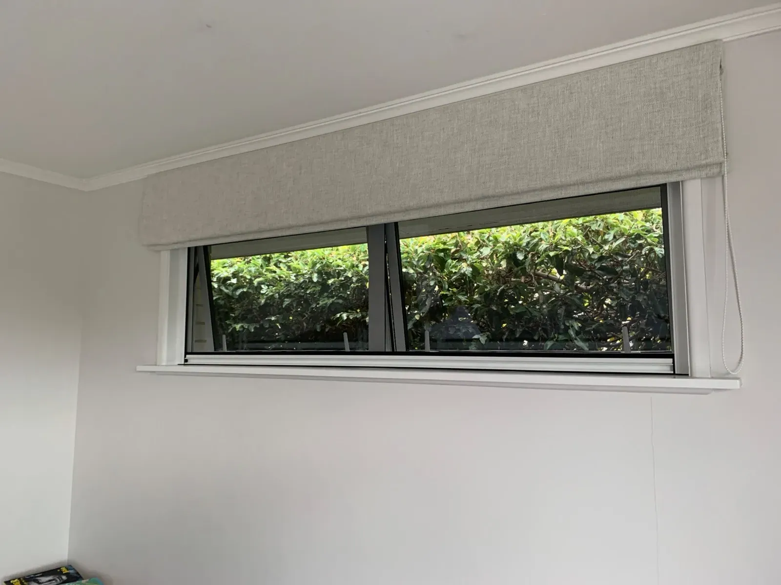 Serene retractable insect screens drawn down over a bank of awning windows, the openings clear behind the mesh