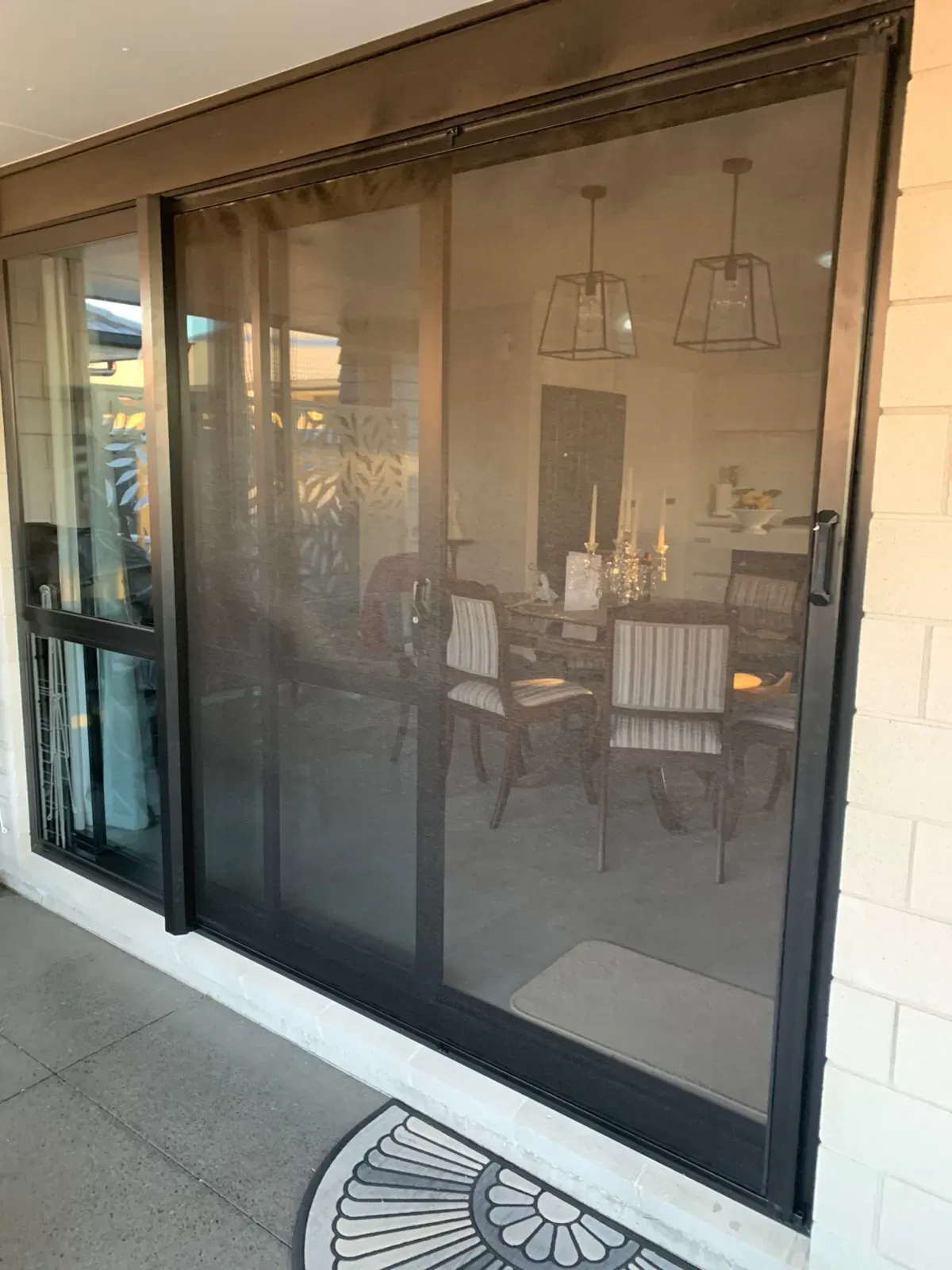 Retractable Wall Screen drawn across a sliding door into a dining room, mesh retained in the side tracks