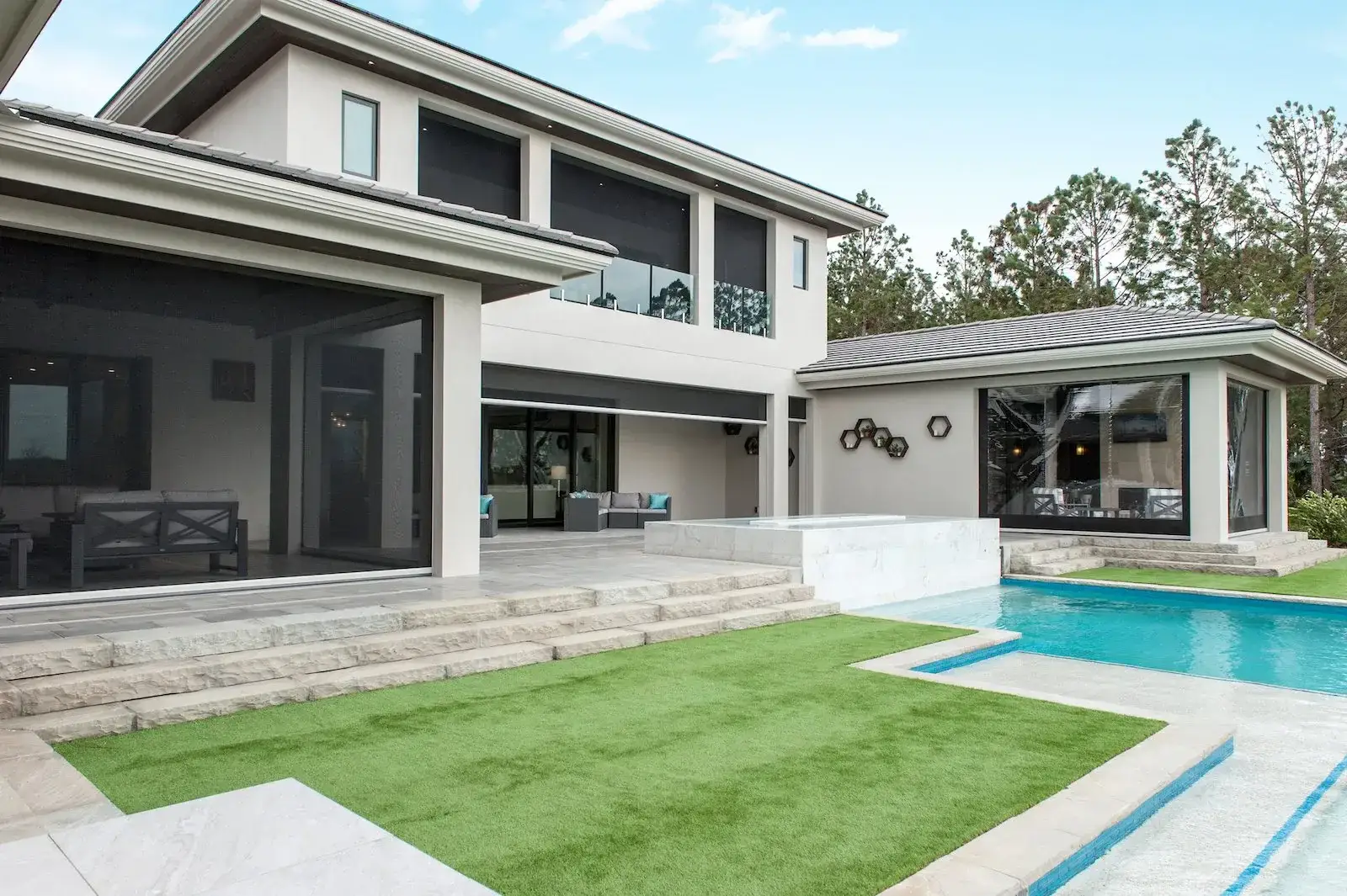 A large contemporary home fitted with motorised outdoor screens across its upstairs balcony and ground-floor openings