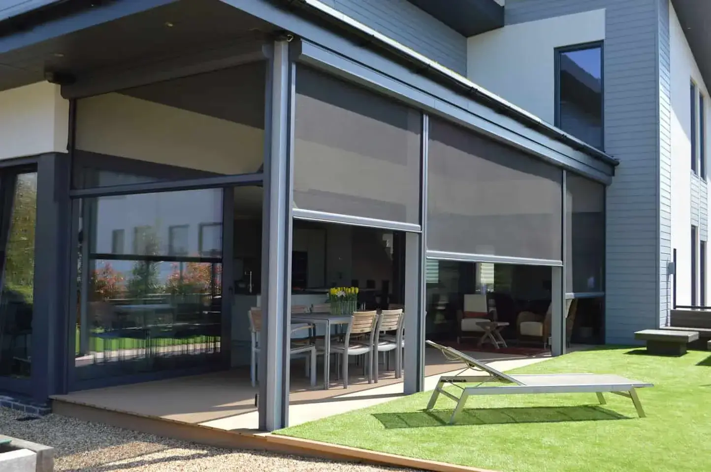 Executive motorised outdoor screens enclosing a covered patio with a dining and lounge area