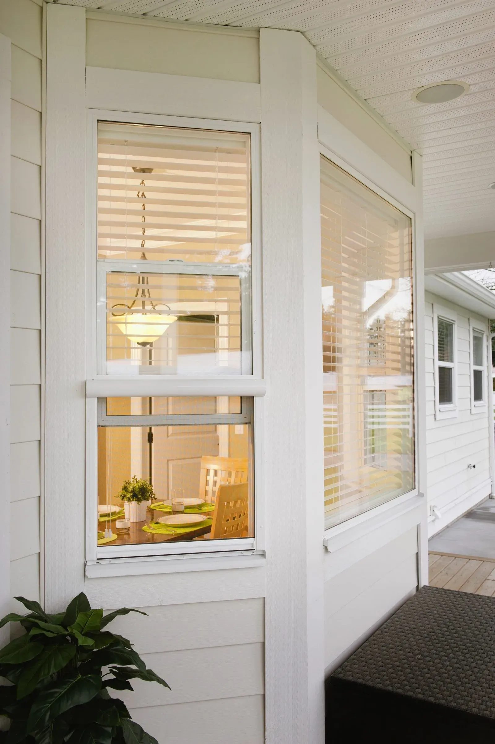 White Serene retractable screen drawn partway down a double-hung window, showing the slim cassette and side tracks