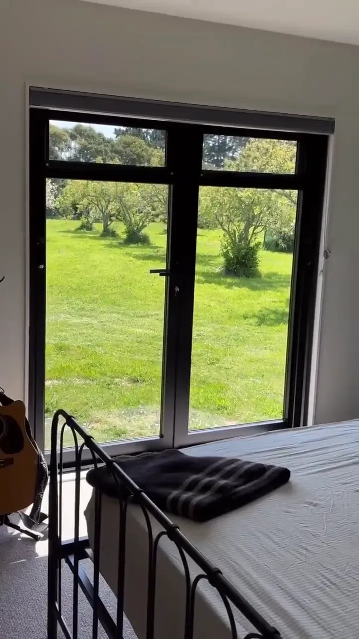 A retractable insect screen drawn across a pair of French doors
