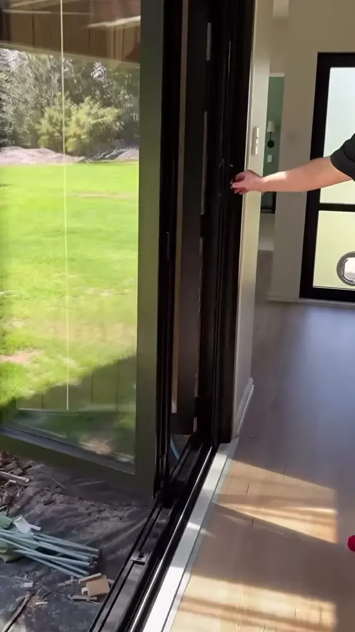 A retractable Wall Screen drawn across a wide bi-fold door opening