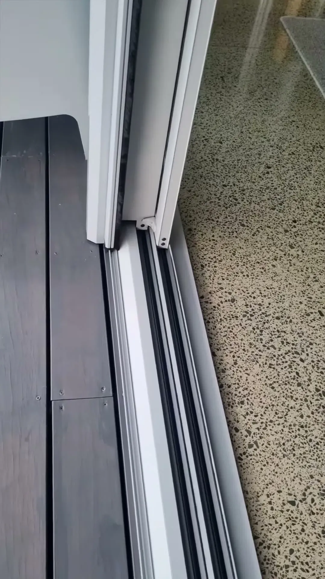 Close-up of a retractable Wall Screen track and sill fitted along a sliding door threshold